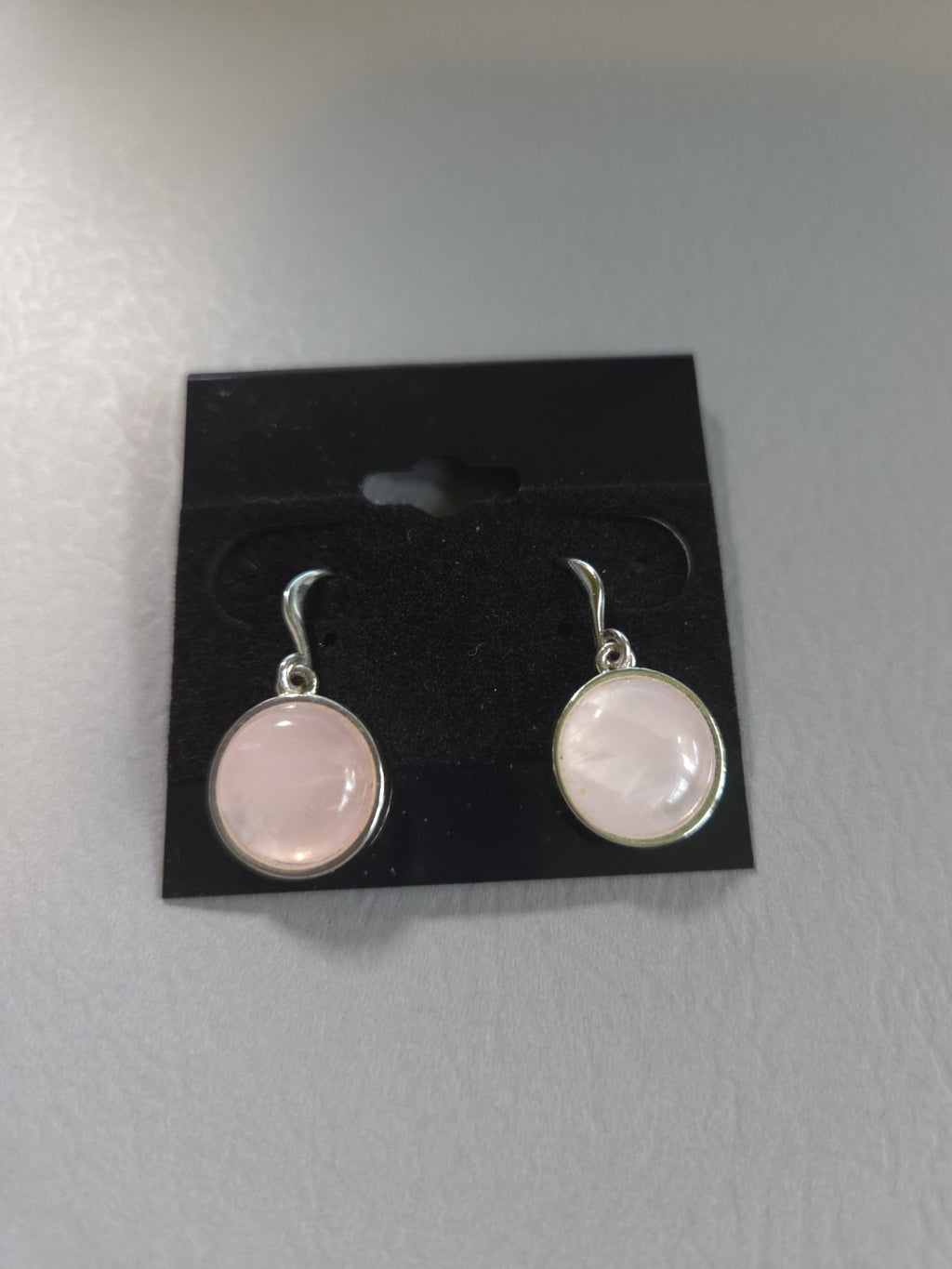 silver-tone drop earrings featuring polished, round pink rose quartz cabochons